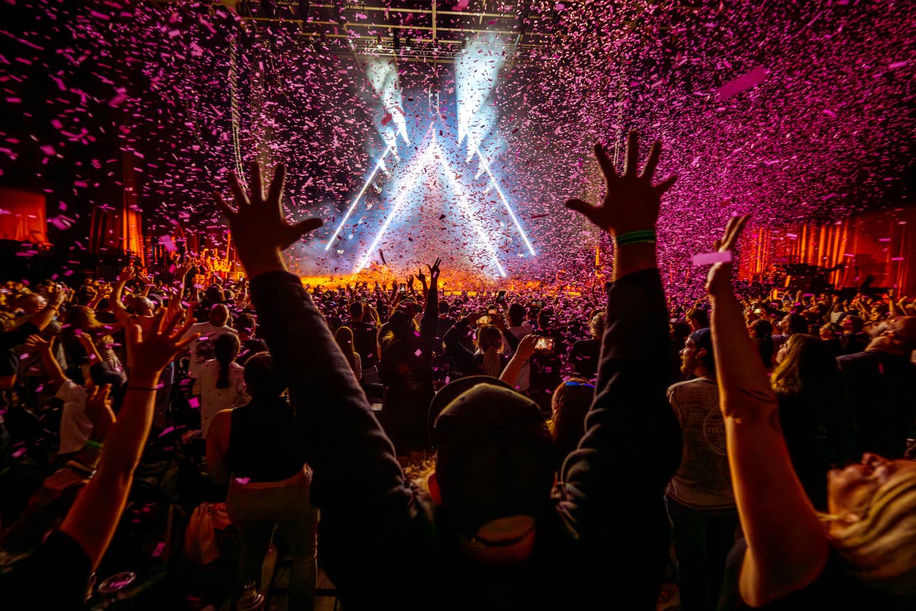 Photo of a fan with his hands up with confetti