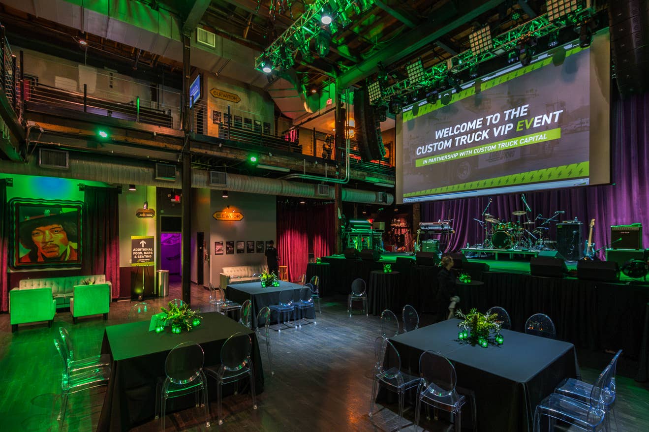 A Special Event setup at the Mercury Ballroom features elegant tables, lounge seating, and a lit stage with instruments ready for a live performance