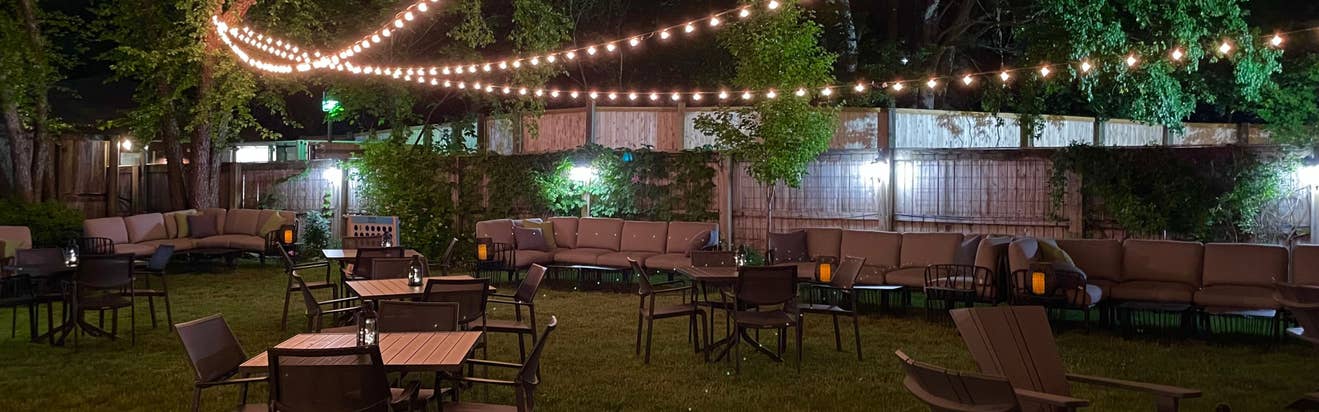 a photo of the VIP club at night with globe lights hanging over luxury seating
