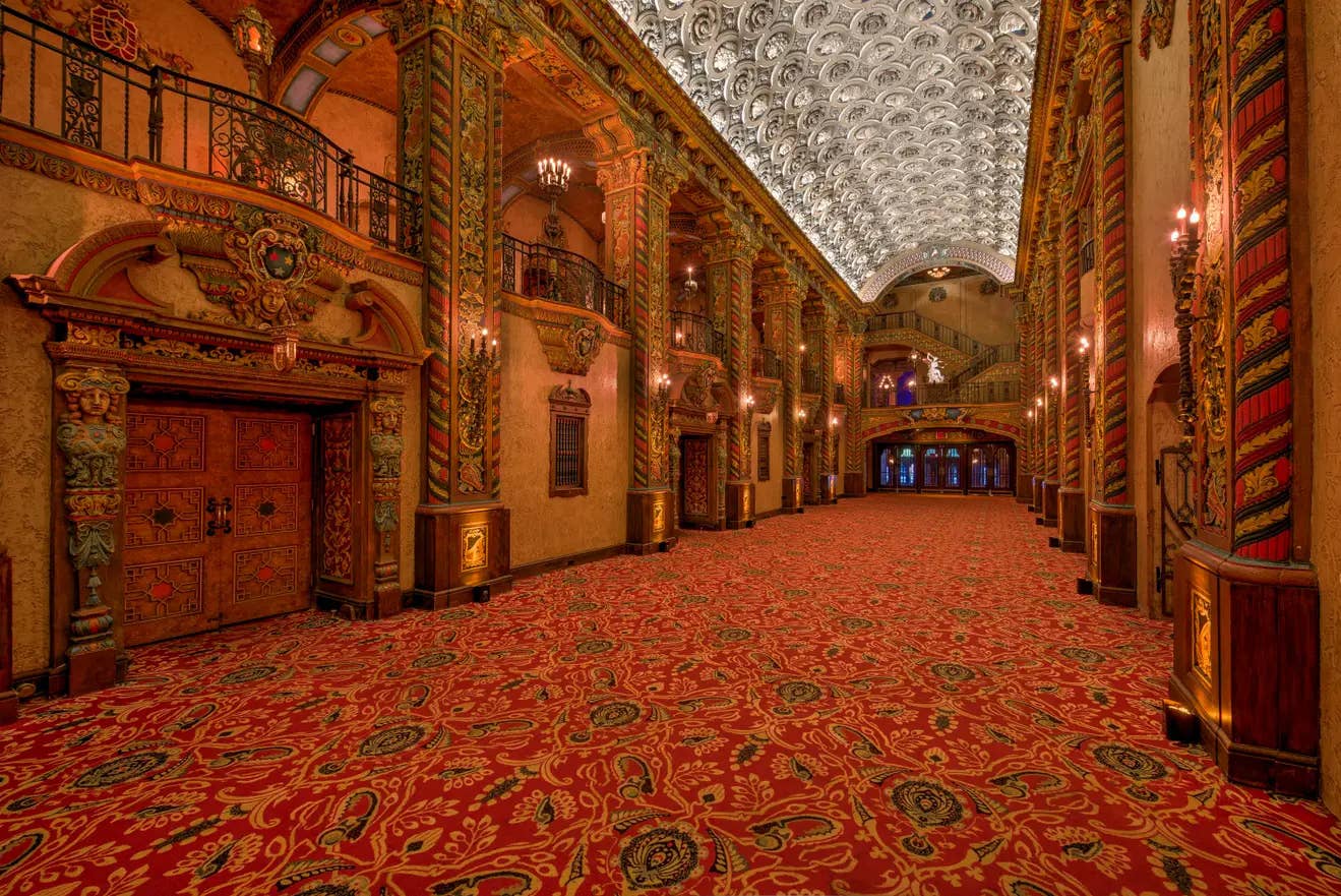 The Faces Lobby with ornate carpeting, tall decorated columns, and a detailed ceiling. 